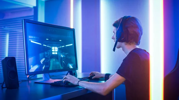 Tiro do jogador profissional jogando em primeira pessoa Shooter Online Video Game em seu computador pessoal. Quarto Lit by Neon Lights em estilo Retro Arcade. Online Cyber e-Sport Campeonato de Internet. — Fotografia de Stock