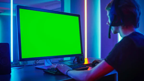 Shot of the Professional Gamer Playing on His Personal Computer with Green Screen Mock-up Template. Room Lit by Neon Lights in Retro Arcade Style. Online Cyber e-Sport Internet Championship. — Stock Photo, Image