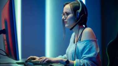 Güzel Profesyonel Oyuncu Kız, Kişisel Bilgisayarında Birinci Şahıs Nişancı Online Video Oyunu 'nda oynuyor. Gözlüklü ve gülümseyen sıradan sevimli inek. İnternet Sanal-Spor Şampiyonası.