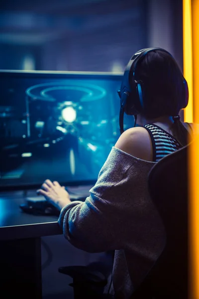 Foto von der Schönen professionellen Spielerin, die in einem Online-Ego-Shooter-Online-Videospiel auf ihrem Personal Computer spielt. Casual Nettes Geek-Mädchen in dunklem Zimmer plötzlich von Neon Lit — Stockfoto