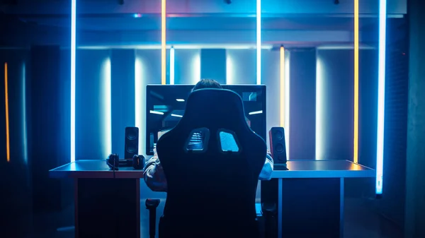 Professional Gamer Playing in First-Person Shooter Online Video Game on His Personal Computer. Room Lit by Neon Lights in Retro Arcade Style. Cyber Sport Championship. — Stock Photo, Image