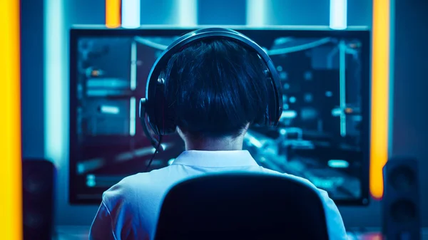 Joueur professionnel jouant à la première personne tireur jeu vidéo en ligne sur son ordinateur personnel. Il parle avec son équipe à travers le casque. Room Lit by Neon Lights dans un style arcade rétro. Cybersport — Photo