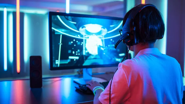 Précédent View of Professional Gamer Playing in First-person Shooter Jeu vidéo en ligne sur son ordinateur personnel. Room Lit by Neon Lights dans un style arcade rétro. Championnat Cyber Sport. — Photo