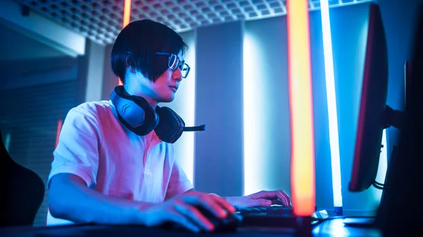 Low Angle Shot eines professionellen ostasiatischen Spielers, der in einem Online-Videospiel auf seinem Personal Computer spielt. Zimmer Lit von Neon Lights im Retro Arcade Stil. Cyber-Sport-Meisterschaft. — Stockfoto