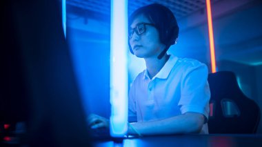 Kişisel Bilgisayarında Online Video Oyunu 'nda oynayan Asyalı profesyonel bir oyuncunun düşük açılı çekimi. Neon Lights 'ın Retro Arcade Style' daki oda aydınlatması. Siber Spor Şampiyonası.