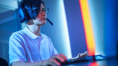 Kişisel Bilgisayarında Online Video Oyunu 'nda oynayan Doğu Asyalı Profesyonel Oyuncuların Hollanda Açısı. Takımına mikrofon kullanarak komutanlık yapıyor. Neon Lights 'ın Retro Arcade Style' daki oda aydınlatması. Siber