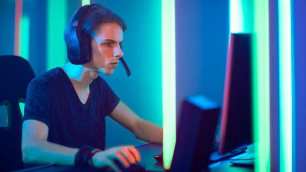 Młody gracz Pro gra w gry wideo online, rozmowy z graczami zespołu za pośrednictwem mikrofonu. Neonowy Pokój Kolorowy. e-Sport Cyber Games Internet Championship. — Zdjęcie stockowe