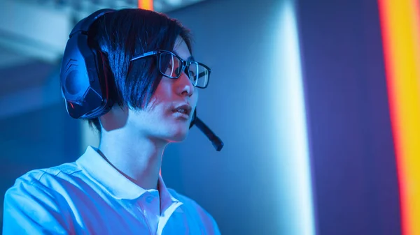 プロ東アジアのゲーマーは、彼のパーソナルコンピュータ上のオンラインビデオゲームでプレイ。マイクを通して彼のチームと話をする。Room Lit by Neon Lights in Retro Arcade Style。サイバースポーツ選手権. — ストック写真
