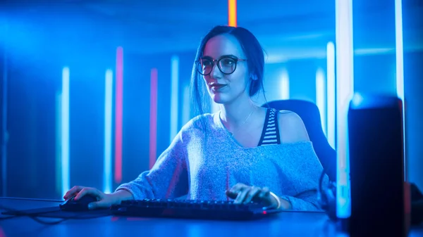 Krásná profesionální hráč dívka hraje a streamování Online videohry na jejím osobním počítači. Nenucený roztomilý šprt s brýlemi. Cyber e-Sport Internet Championship v Neon Lights. — Stock fotografie