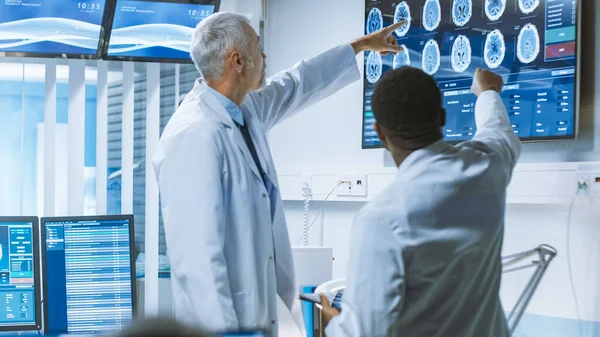 Equipe de Cientistas Profissionais Trabalham no Laboratório de Pesquisa Cerebral. Neurologistas Neurocientistas Rodeados por Monitores Mostrando CT, MRI Scans Discutindo e Trabalhando em Computadores Pessoais. — Fotografia de Stock