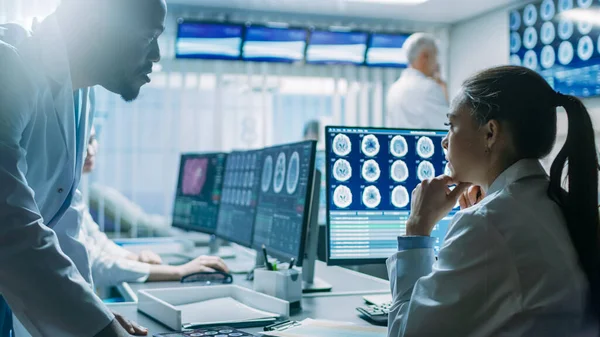 Dois cientistas médicos no trabalho do Laboratório de Pesquisa Cerebral. Neurocientistas usam computador pessoal com ressonância magnética, tomografia computadorizada mostram imagens do cérebro. — Fotografia de Stock