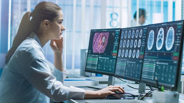 Жіночий науковий співробітник з медичних досліджень працює з скануванням мозку на її персональному комп'ютері. Сучасна лабораторія працює над неврофізіологією, наукою, нейрофармакологією. Розуміння людського мозку. — стокове фото