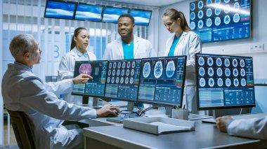 Profesyonel Tıp Bilim Adamları Ekibi Beyin Araştırma Laboratuvarı 'nda çalışıyor. Nörologlar Isıtmalı Tartışma Yapan Nörologlar Tomografi ve MRI Taramalarını Gösteren Monitörlerle çevrili.