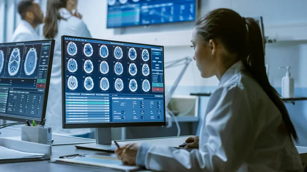 Γυναίκα Επιστήμονας Ιατρικής Έρευνας Εργάζεται με σαρώσεις εγκεφάλου στον προσωπικό υπολογιστή της, Γράφοντας τα δεδομένα σε ένα πρόχειρο πίνακα. Σύγχρονο Εργαστήριο Νευροφυσιολογίας, Επιστήμης, Νευροφαρμακολογίας. — Φωτογραφία Αρχείου