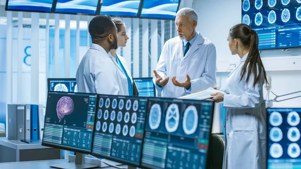 Möte med forskarlaget i hjärnforskningslaboratoriet. Neurologer Neuroforskare som har upphettad diskussion omgiven av monitorer som visar datortomografi, MRT-skanningar. — Stockfoto