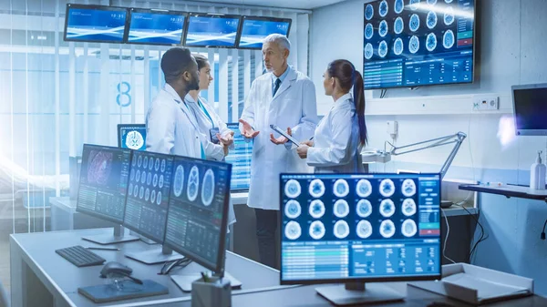 Bijeenkomst van het team van medische wetenschappers in het laboratorium voor hersenonderzoek. Neurologen Neurowetenschappers hebben verwarmde discussie omgeven door monitoren Toont CT, MRI-scans. — Stockfoto