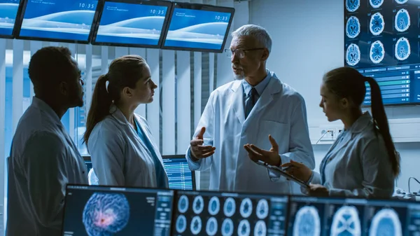 Möte med forskargruppen vid hjärnforskningslaboratoriet. Neurologer Neuroforskare som har medicinsk diskussion omgiven av monitorer som visar datortomografi, magnetröntgen. — Stockfoto