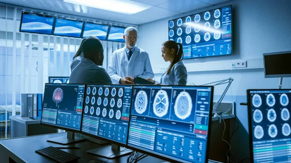 Spotkanie Zespołu Naukowców Medycznych w Laboratorium Badań Mózgu. Neurolodzy Neurolodzy Dyskusja analityczna otoczeni przez monitory pokazujące tomografię komputerową, skany rezonansowe. — Zdjęcie stockowe