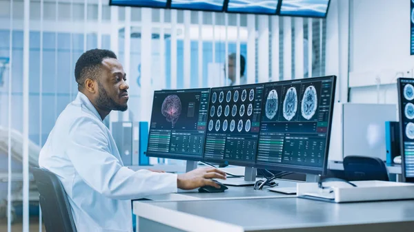 Ιατρικός Επιστήμονας Εργάζεται με αξονική τομογραφία εγκεφάλου Εικόνες σε έναν προσωπικό υπολογιστή στο εργαστήριο. Νευρολόγοι στο Νευρολογικό Ερευνητικό Κέντρο Εργάζονται σε μια θεραπεία όγκου του εγκεφάλου. — Φωτογραφία Αρχείου