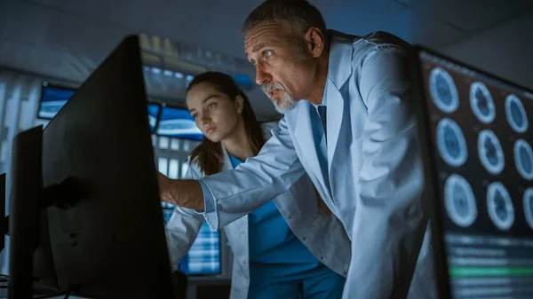 Two Medical Scientists Neurologists, Talking and Working on a Personal Computer in Modern Laboratory. Research Scientists Making New Discoveries in the fields of Neurophysiology, Science — Stock Photo, Image