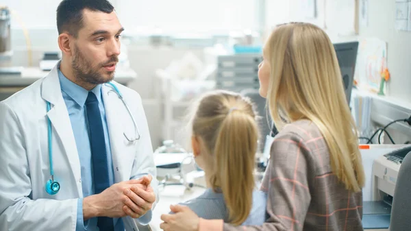 Vriendelijke dokter doet Routine onderzoek van een lief klein meisje die kwam met haar moeder. Pediater praat met hen beiden. Artsen Bureau is Helder en Modern. — Stockfoto