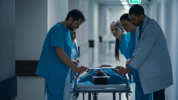 Notaufnahme: Ärzte, Krankenschwestern und Sanitäter schieben Gurney-Trage mit schwer verletztem Patienten in den Operationssaal. Helles modernes Krankenhaus mit professionellem Personal, das Leben rettet. — Stockfoto
