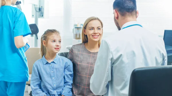 Madre con Dulce Niña Visita Amistosa Pediatra. El doctor habla con ellos después de un examen exhaustivo. Brightand Oficina Médica Moderna. —  Fotos de Stock