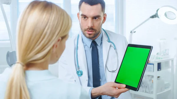 Über die Schulter einer Patientin, die mit einem professionellen Arzt spricht, der ihren digitalen Tablet-Computer mit Green-Screen-Attrappe zeigt. — Stockfoto