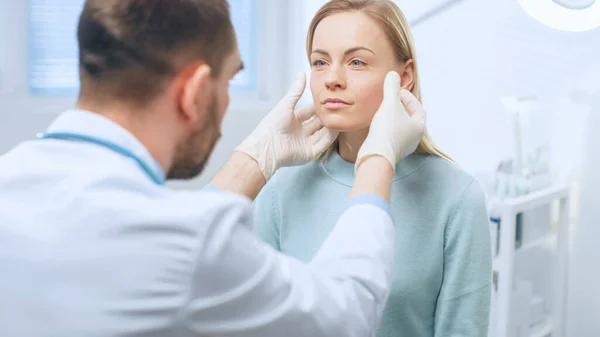 Cirujano cosmético plástico examina la cara hermosa de las mujeres, la toca con las manos enguantadas, inspeccionando la cara curada después de la cirugía plástica con resultados asombrosos. —  Fotos de Stock