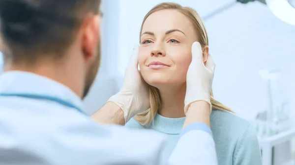 Cirujano cosmético plástico examina la cara hermosa de las mujeres, la toca con las manos enguantadas, inspeccionando la cara curada después de la cirugía plástica con resultados asombrosos. —  Fotos de Stock