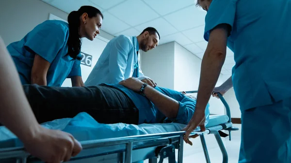 Emergency Department: Doctors, Nurses and Paramedics Run and Push Gurney Stretcher with Seriously Injured Patient towards the Operating Room. Bright Modern Hospital with Professional Staff.