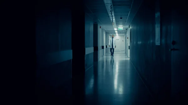 Medical Doctor Walks into Dark Part of the Hospital Corridor.