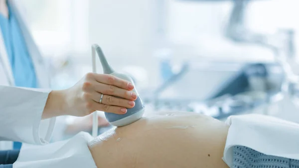Im Krankenhaus Großaufnahme des Geburtshelfers mit Transducer für Ultraschall-Sonogramm-Screening des Bauches der Schwangeren. — Stockfoto