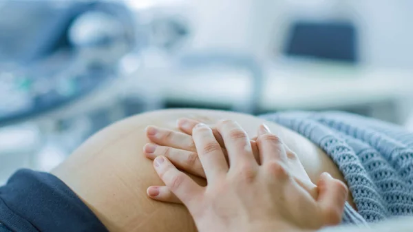 Primo piano sulla pancia delle donne incinte, lei e suo marito toccarlo con attenzione, cercando di sentire se il bambino calci. — Foto Stock