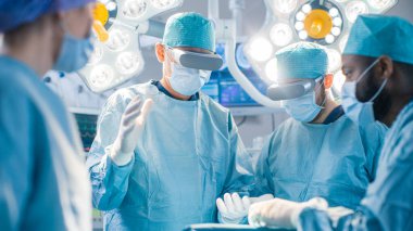 Artırılmış Gerçeklik Gözlüğü Giyen Cerrahlar Yüksek Teknoloji Hastanesi 'nde Gelişmiş Gerçeklik Cerrahlığı' nı sahneledi. Ameliyathanede çalışan doktorlar ve asistanlar..