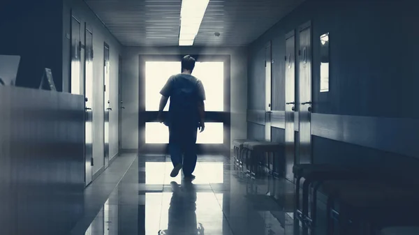 Στο Νοσοκομείο Ηλικιωμένων Συνταξιούχος άνθρωπος περπατά κάτω από το διάδρομο με το φως στο τέλος. Καθαρή σύγχρονη ιατρική εγκατάσταση. Ζωή μετά το θάνατο, Πόρτα στον Παράδεισο Έννοια. — Φωτογραφία Αρχείου