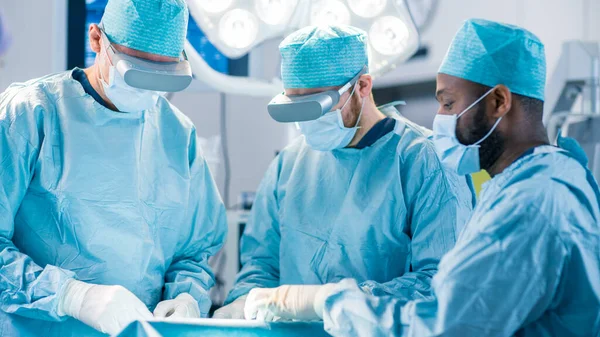 증강현실 유리를 착용하는 외과 의사들은 첨단 기술 병원에서 현실 수술을 혼합 한 상태를 유지 한다. 수술 실에서 일하는 의사들과 석면. — 스톡 사진