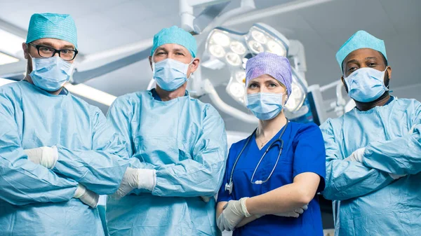 Diverse Team of Professional surgeon,  Assistants and Nurses Standing Proudly with Crossed Arms in the Real Modern Hospital with Authentic Equipment.