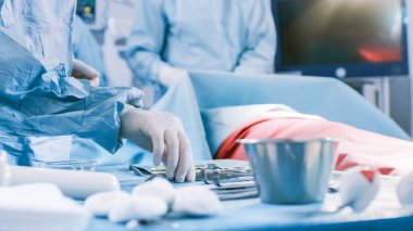 Ameliyat sırasında Cerrahi Masa 'nın Ameliyat Odası' nda Asistan Cerrahlara Aletleri Verirken Yakın Çekim. Ameliyat devam ediyor. Profesyonel Tıp Doktorları