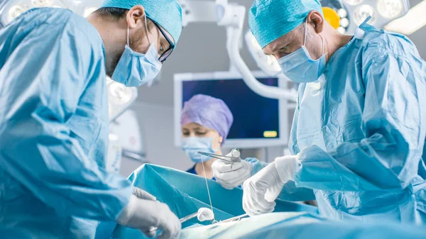 W sali operacyjnej Szpitala Zróżnicowany zespół profesjonalnych chirurgów i pielęgniarek Rana szarpana po udanej operacji. — Zdjęcie stockowe