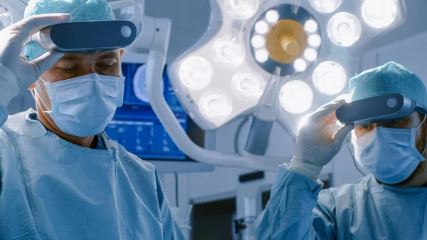 Surgeons Remove Augmented Reality Glasses after Performing State of the Art Surgery in High Tech Hospital. Doctors and Assistants Working in Operating Room.