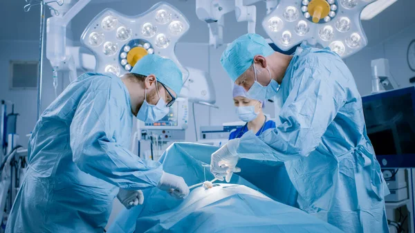 Nella sala operatoria dell'ospedale Diversi team di chirurghi professionisti e infermieri Suture ferito dopo un intervento chirurgico di successo. — Foto Stock