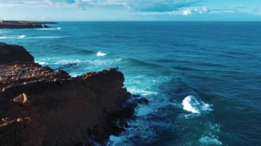 Hava Aracı Görüntüsü: Güzel Okyanus Manzaralı Portekiz Rocky Shore. Portekiz üzerinde uçmak, Oceanic Waves 'le sahil şeridi yuvarlanmak, uçurumlara çarpmak. Yalnız Balıkçı Balık Tutuyor. Praia Do Guincho