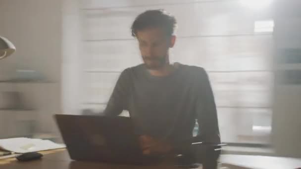 Homem criativo profissional sentado em sua mesa no Home Office Studio Trabalhando em um laptop escreve notas. Energético Fast Paced Time-Lapse Fast forward Movimento. tiro de arco de rastreamento de 360 graus — Vídeo de Stock