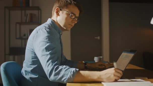 Hombre creativo profesional sentado en su escritorio en Home Office Studio Trabajando en un ordenador portátil. Man working with Data and Analyzing Statistics. Cámara moviéndose. Movimiento de tiro de arco de seguimiento de 360 grados — Vídeo de stock