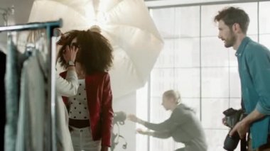 Fotoğraf çekiminin kulisinde: Makyöz, Güzel Siyah Modele Makyaj Uygular, Profesyonel Kamerayla Fotoğraf Çekmeye Başlar. Moda Dergisi Stüdyo Fotoğrafları