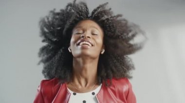 Moda dergisi için çekici siyah kız pozu veren bir fotoğrafçı. Moda dergisi için Profesyonel Stüdyo Fotoğraf Çekimi sırasında Güzel Kız Gülümsüyor. Kırmızı sahte deri ceket giyiyor.