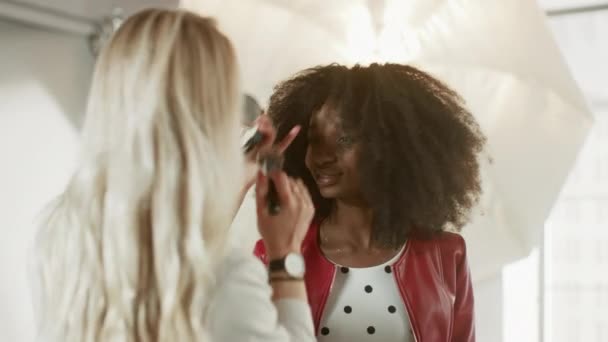 Backstage of the Photo Shoot : Make-up Artist Applies Makeup on Beautiful Black Model, in a Moment Le photographe commence à prendre des photos avec un appareil photo professionnel. Magazine de mode Studio Photoshoot — Video