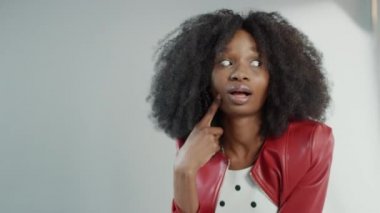 Moda dergisi için kıvırcık saçlı çekici siyah kız pozu veren bir fotoğrafçı. Düşünceli İfadesiyle Aylaklık Eder. Moda Dergisi için Profesyonel Stüdyo Fotoğraf Çekimi