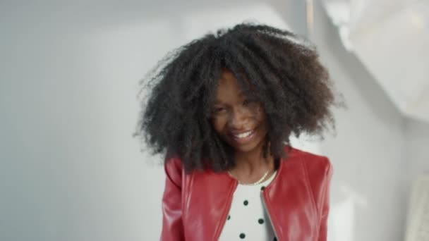 Atractiva chica negra con el pelo rizado exuberante posando para una sesión de fotos de la revista de moda. Hermosa chica sonríe durante la sesión de fotos del estudio profesional. Tiro de retrato — Vídeos de Stock